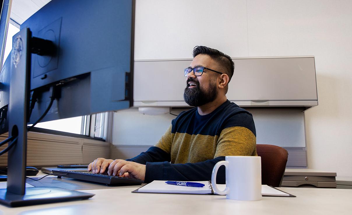 A man sits at a computer using AGLC&#039;s learning management system